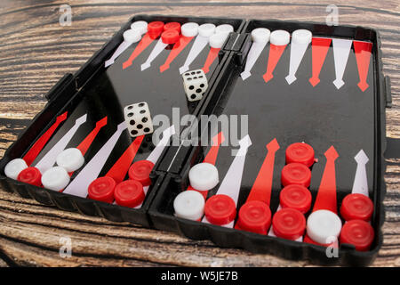 Small pocket backgammon on a wooden table. Stock Photo