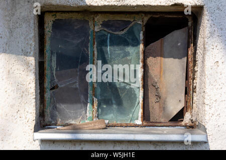 A rusty window with broken glass panes Stock Photo