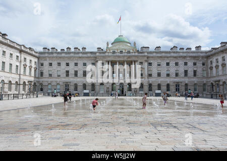 Children playing in the water fountains in the  neoclassical Somerset House Courtyard, London, England, UK Stock Photo