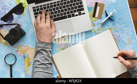 Young man choosing trip on his laptop online Stock Photo