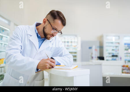 Attentive male person making notes during revision Stock Photo