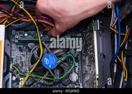 Computer repairing. Man repair black pc Stock Photo