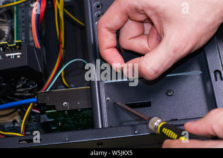 Computer repairing. Man repair black pc Stock Photo