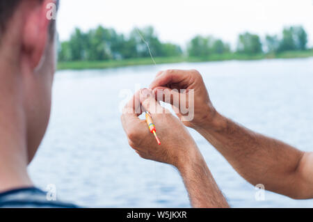 Father teaching son how to fishing in river Stock Photo