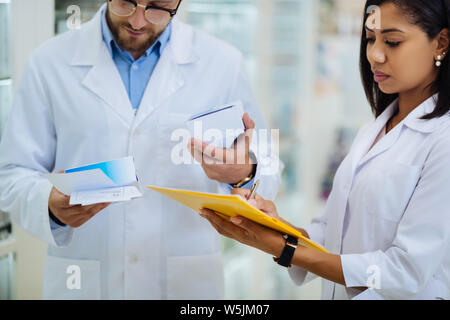 Attentive brunette female making notes during revision Stock Photo