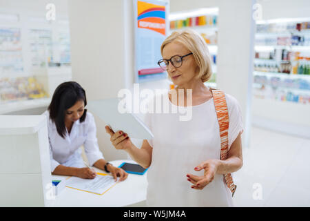 Cheerful blonde female person reading her notes Stock Photo