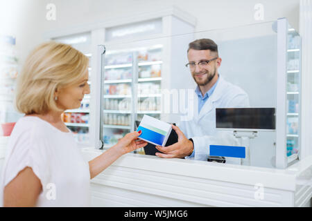 Positive delighted bearded man working in chemists shop Stock Photo