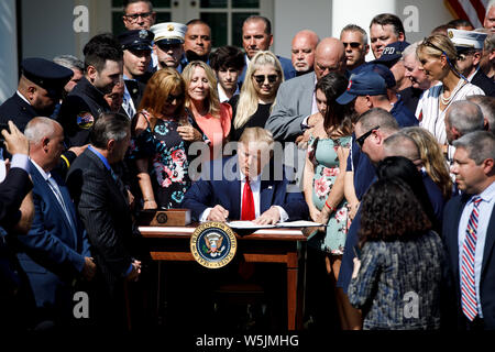 Washington DC, USA. 29th July 2019. U.S. President Donald Trump (C) participates in a signing ceremony for the 'Permanent Authorization of the September 11th Victim Compensation Fund Act' at the White House in Washington, DC, the United States, on July 29, 2019. U.S. President Donald Trump on Monday signed into law a bill that extends funding for victims of the Sept. 11 terror attacks. (Photo by Ting Shen/Xinhua) Credit: Xinhua/Alamy Live News Stock Photo