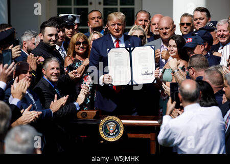 Washington DC, USA. 29th July 2019. U.S. President Donald Trump (C) participates in a signing ceremony for the 'Permanent Authorization of the September 11th Victim Compensation Fund Act' at the White House in Washington, DC, the United States, on July 29, 2019. U.S. President Donald Trump on Monday signed into law a bill that extends funding for victims of the Sept. 11 terror attacks. (Photo by Ting Shen/Xinhua) Credit: Xinhua/Alamy Live News Stock Photo