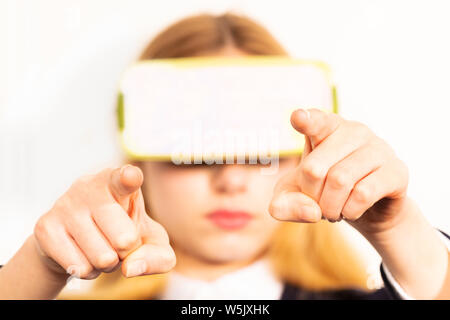 Woman wearing Virtual Reality headset manipulate with fingers imaginary object Stock Photo