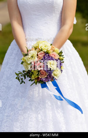 Beautiful wedding bouquet in hands of the bride Stock Photo