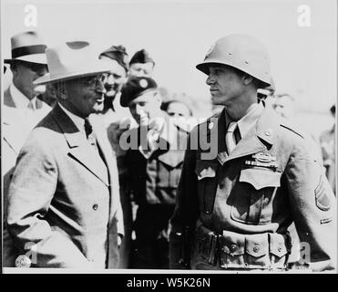 At an airfield near Brussels, Belgium President Harry S. Truman, en route to the Potsdam Conference in Germany, speaks to a member of the 137th Regiment of the 35th Division. The 35th Division was designated as honor guard because it was the President's outfit in World War I. The soldier speaking to the President is Staff Sgt. Ernie Atkin of Madisonvale, Tennessee. Stock Photo