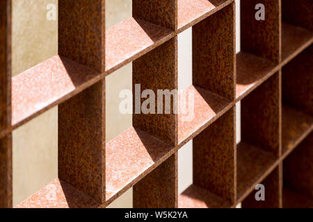 Abstract view of square grid pattern of rusty metal gate in the main courtyard area of the Art District of the Citadel of Cascais, Cascais, Portugal. Stock Photo