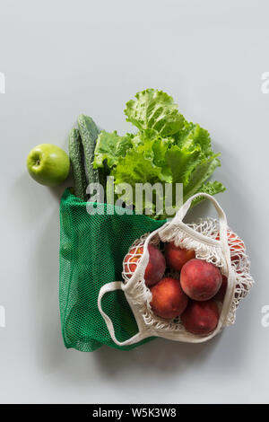 Zero waste concept. Modern shopping textile bag with fresh peach and vegetables. View from above. Stock Photo