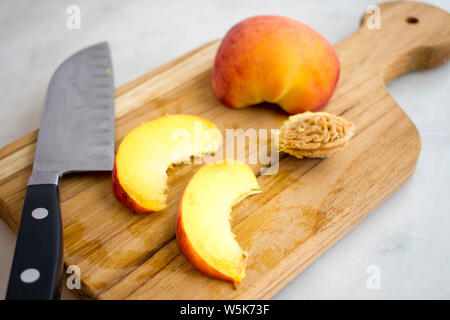 Slicing Peaches on a Wood Cutting Board Stock Photo