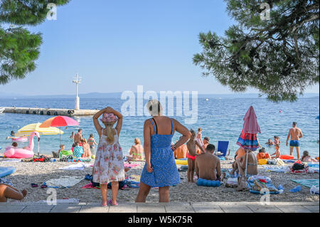 Tourists enjoy the beach at Brela. The Makarska riviera in Croatia is famous for its beautiful pebbly beaches and crystal clear water. Stock Photo