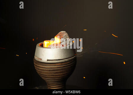 Coals for hookah close-up. Burning coals on a hookah bowl. Stock Photo