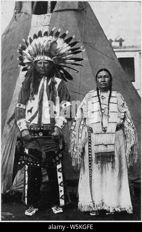 Circus Sarrasani - Two Sioux Indians in native dress in front of teepee; Scope and content:  Post card souviner of Circus Sarrasani. The caption, in English and German, reads Real Sioux Indians from Pine Ridge South Dakota. They are in Europa with Clarence Shultz, the well known cowboy from Marland Oklahoma U.S.A. Stock Photo