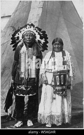 Circus Sarrasani - Two Sioux Indians in native dress in front of teepee; Scope and content:  Post card souviner of Circus Sarrasani. The caption, in English and German, reads Real Sioux Indians from Pine Ridge South Dakota. They are in Europa with Clarence Shultz, the well known cowboy from Marland Oklahoma U.S.A. Stock Photo