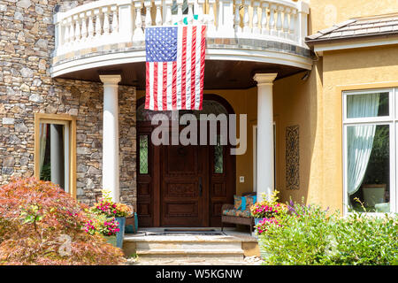 American Flag hanging over front door of a home Stock Photo