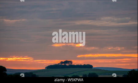 Weather UK: Spectacular sunset over Minnning Low hill Historic England monument with a chambered tomb & two bowl barrows, Peak District, UK