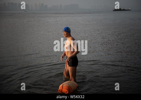 53-year-old Chinese man Zhu Biwu, known locally as River Crossing Brother, swims across the Yangtze River to get to work in Wuhan city, central China' Stock Photo