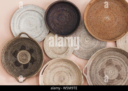 Wall decorated with different wicker handmade trays and baskets. Eco style and concept, Moroccan culture. Stock Photo