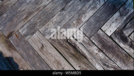 Weathered, graying wooden planks arranged in a herringbone pattern Stock Photo