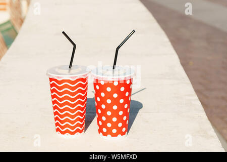 Two cocktails in disposable paper cups. Coffee and lemonade to go take away. Concept of a walk together Stock Photo