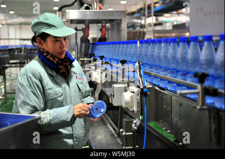 --FILE--A Chinese worker checks bottles of Wahaha purified water on the ...