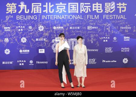 Chinese actress Bai Baihe, left, and film and television director and producer Li Shaohong, pose as they arrive on the red carpet for the opening cere Stock Photo