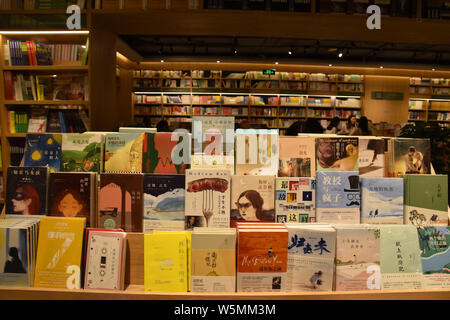 Customers read books at a new bookstore stacked with the innovative wraparound shelving units in Hohhot city, north China's Inner Mongolia Autonomous Stock Photo