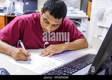 Miami Beach Florida,Mt. Mount Sinai Medical Center,hospital healthcare doctor's office front desk,medical receptionist writing fills filling out form, Stock Photo