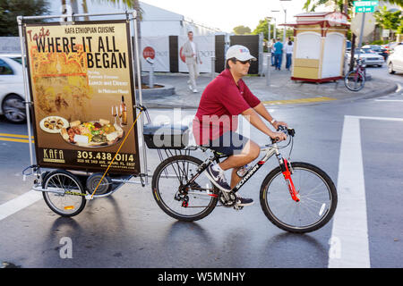 Miami Florida,Midtown,man men male,bicycle billboard,advertisement,ad,mobile ad,advertising,working,work,employee worker workers staff,pedal,man men m Stock Photo