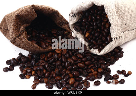 Photo of coffee beans spilling from a jute sack or pouch shot on white background Stock Photo