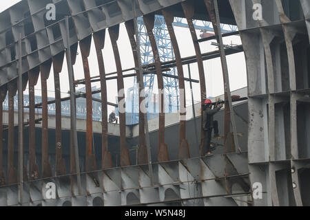 --FILE--Chinese workers manufacture a cargo ship at a factory in Guanyun county, Lianyungang city, east China's Jiangsu province, 12 February 2019. Stock Photo