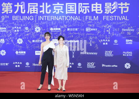 Chinese actress Bai Baihe, left, and film and television director and producer Li Shaohong, pose as they arrive on the red carpet for the opening cere Stock Photo