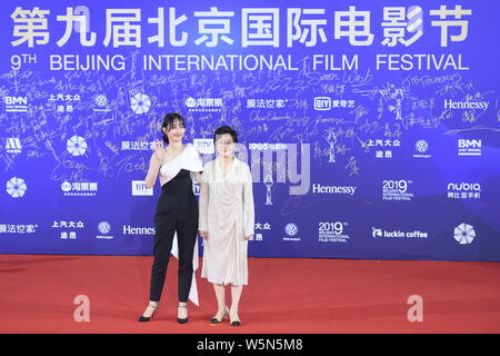 Chinese actress Bai Baihe, left, and film and television director and producer Li Shaohong, pose as they arrive on the red carpet for the opening cere Stock Photo