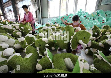 --FILE--Female Chinese workers make soft toys to be exported to the United States and Europe at a factory in Lianyungang city, east China's Jiangsu pr Stock Photo