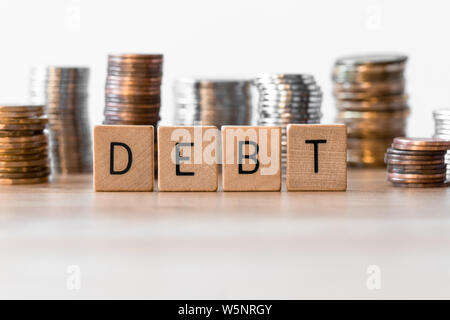 Debt sign with coins in the background Stock Photo