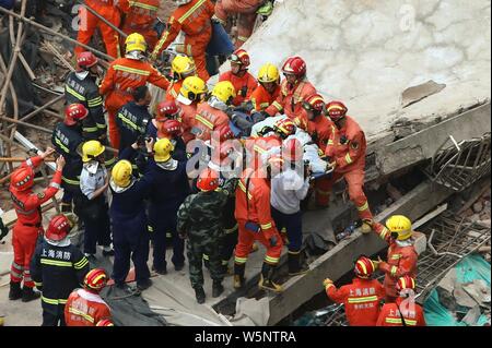 Chinese rescuers pass on a person rescued from the debris of the collapsed building in Shanghai, China, 16 May 2019.   Ten people were killed and anot Stock Photo