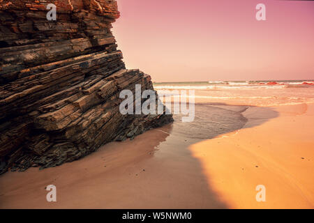 Rocky coast after sunrise. Natural landscape. Rock on the beach early in the morning. Beach at low tide Stock Photo