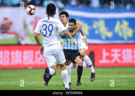 Belgian football player Yannick Ferreira Carrasco, center, of Dalian Yifang passes the ball against players of Shanghai Greenland Shenhua in their 11t Stock Photo