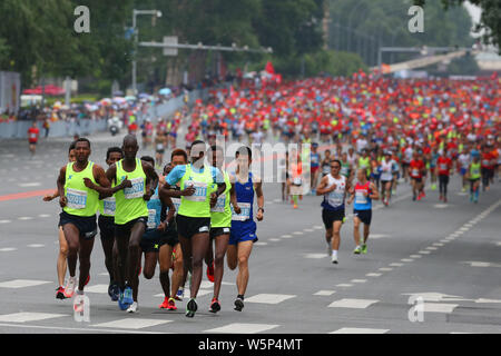 Participants run from the starting line against heavy rain during the Changchun International Marathon in Changchun city, northeast China's Jilin prov Stock Photo