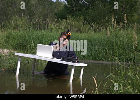 Young bearded millennial man tired of office work Doing stupid things in the workplace. Stock Photo