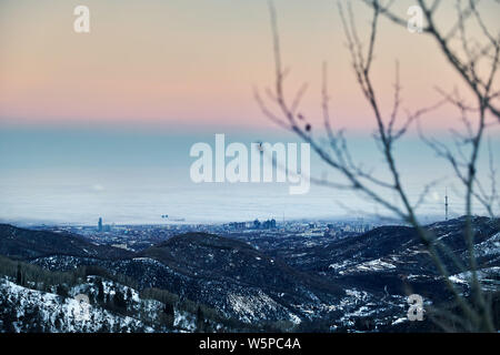 Foggy Almaty city view from the mountains at winter in Kazakhstan, Central Asia Stock Photo