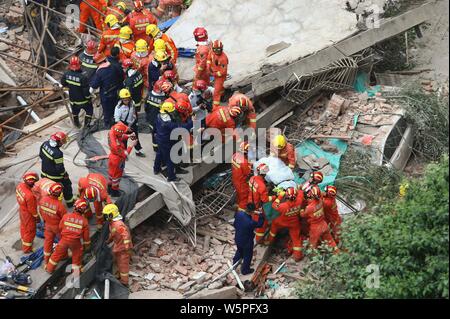 Chinese rescuers pass on a person rescued from the debris of the collapsed building in Shanghai, China, 16 May 2019.   Ten people were killed and anot Stock Photo