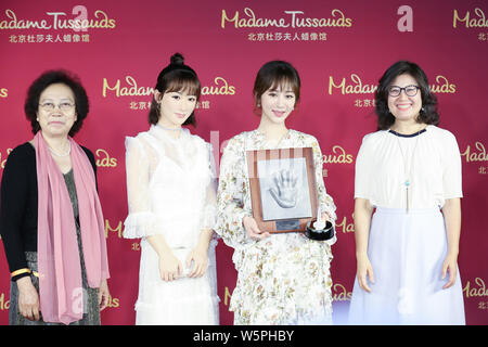 Chinese actress Andy Yang or Yang Zi, second right, poses with the wax figure of her during an unveiling ceremony at the Madame Tussauds museum in Bei Stock Photo