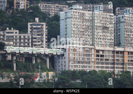 --FILE--A monorail train drives into a building at the Liziba Station of Chongqing Light Rail Line 2 in Chongqing, China, 13 May 2018. Stock Photo