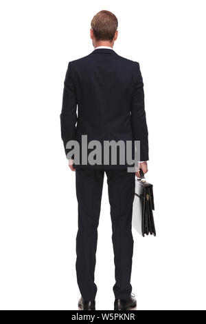 back view of relaxed businessman holding a briefcase and standing on white background with hand in pocket Stock Photo